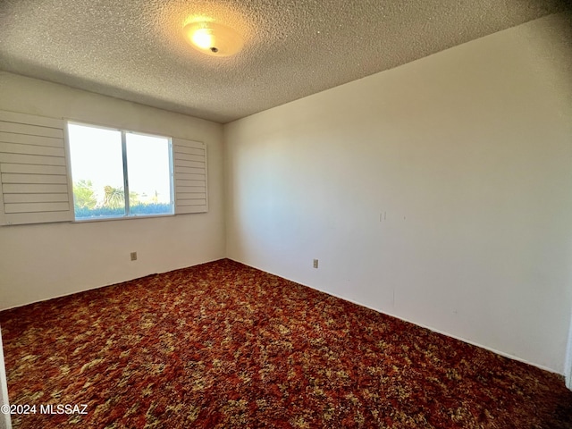 spare room featuring carpet and a textured ceiling