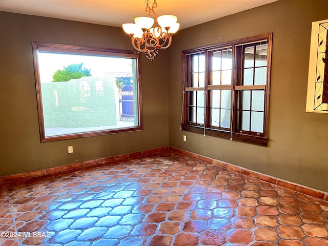 unfurnished dining area featuring plenty of natural light and an inviting chandelier