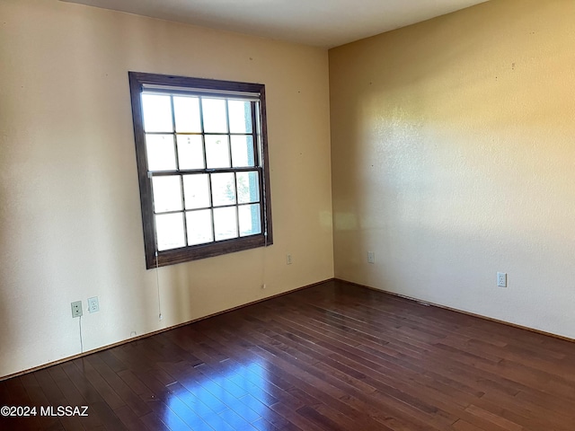 spare room featuring dark wood-type flooring