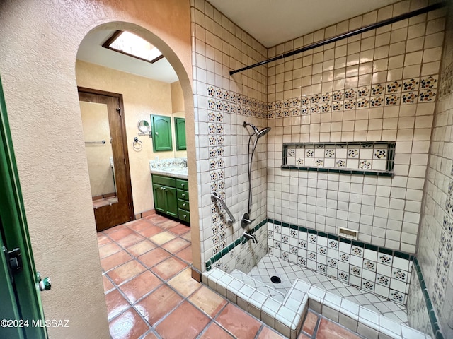 bathroom with tile patterned floors, vanity, and tiled shower