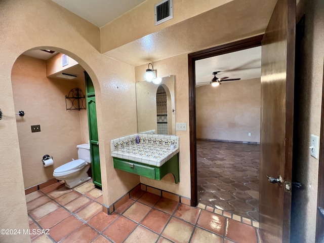 bathroom featuring ceiling fan, tile patterned flooring, and toilet