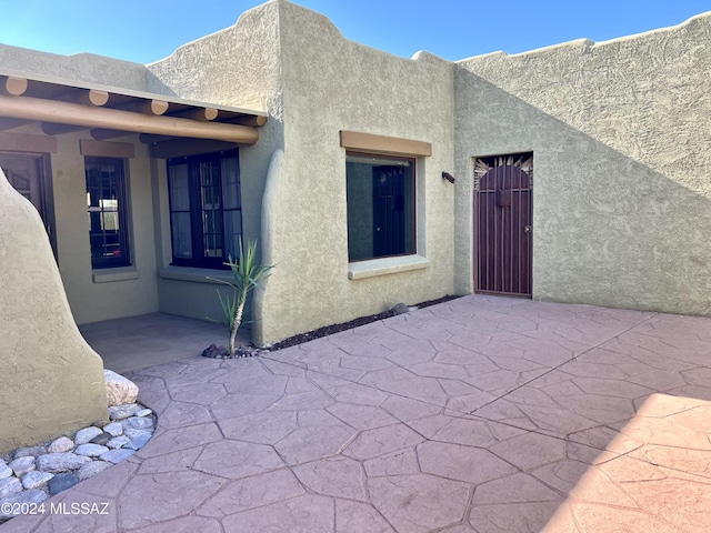 view of exterior entry featuring a patio area