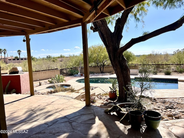 view of patio / terrace with a swimming pool with hot tub