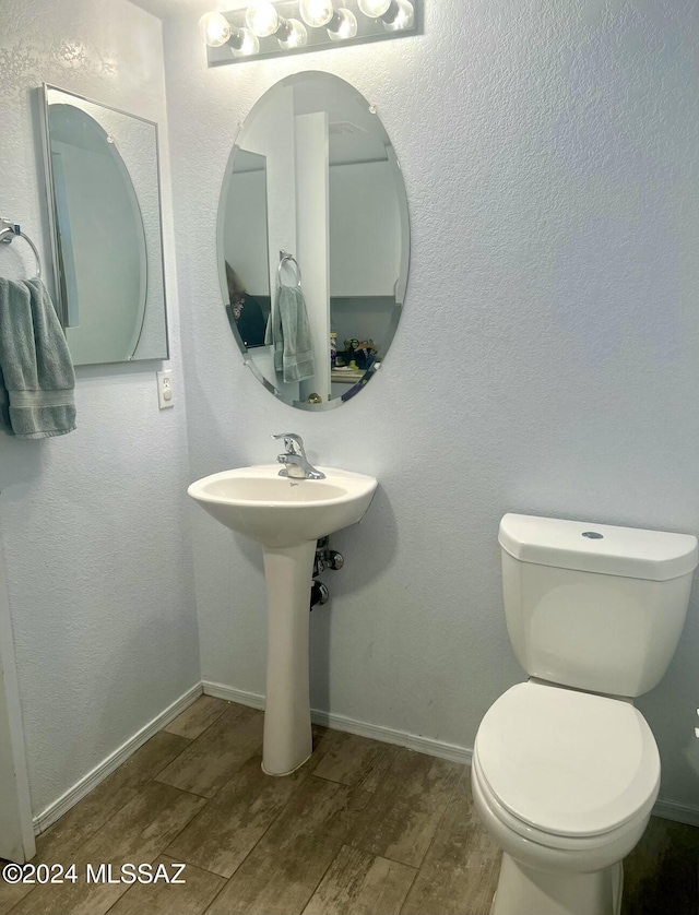 bathroom with sink, toilet, and hardwood / wood-style flooring