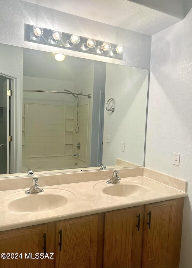 bathroom with vanity, a textured ceiling, and bathtub / shower combination