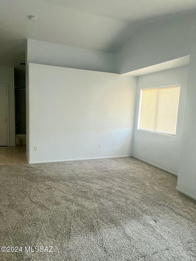 empty room with carpet and lofted ceiling