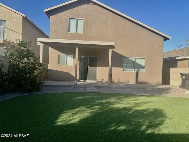 back of property with a yard and a patio