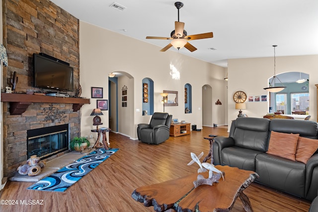 living room with ceiling fan, wood-type flooring, and a fireplace