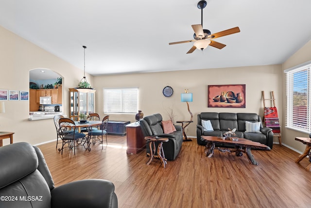 living room featuring plenty of natural light, ceiling fan, vaulted ceiling, and light hardwood / wood-style flooring