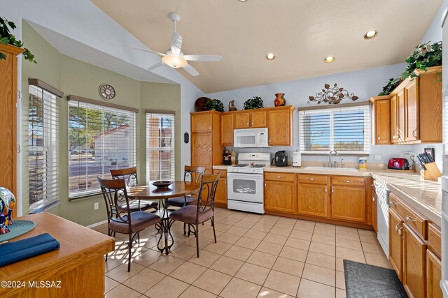 kitchen with lofted ceiling, white appliances, a healthy amount of sunlight, and sink