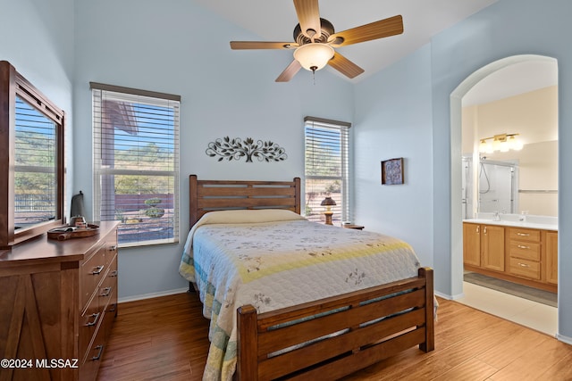 bedroom featuring multiple windows, ensuite bath, and light hardwood / wood-style floors