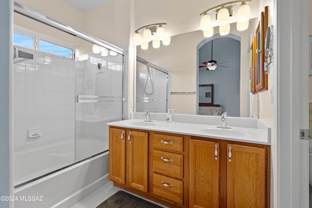 bathroom with ceiling fan, vanity, and enclosed tub / shower combo