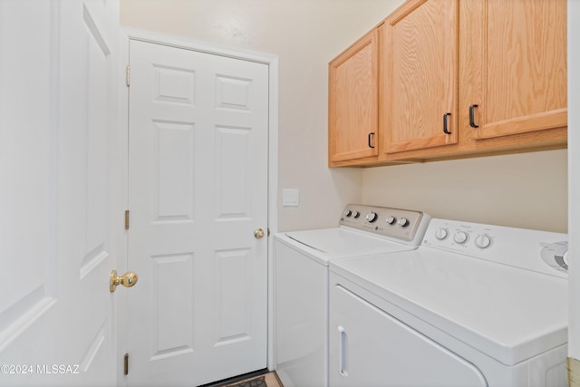 laundry room with washer and dryer and cabinets