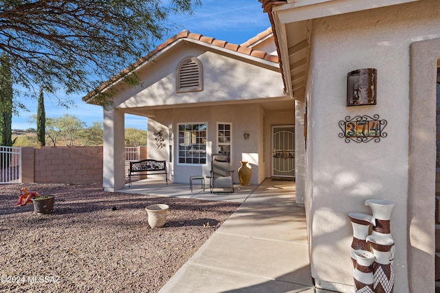 view of exterior entry featuring a patio