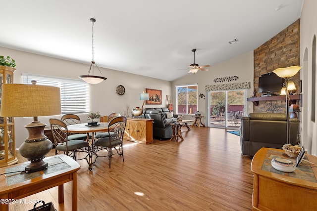 dining area with ceiling fan, vaulted ceiling, and light wood-type flooring