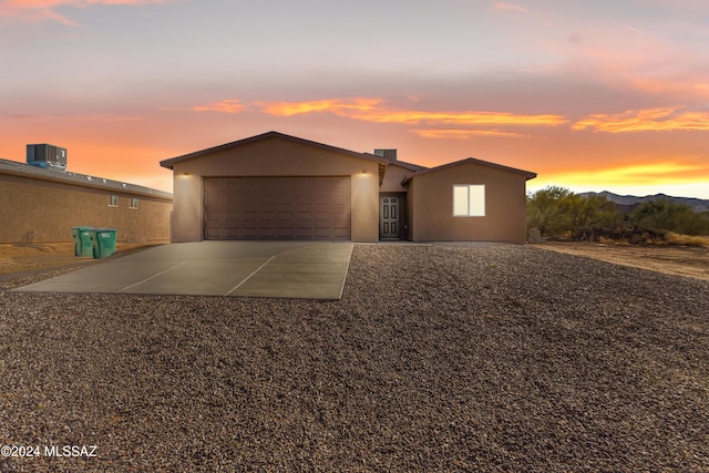 view of front of home featuring central AC unit and a garage