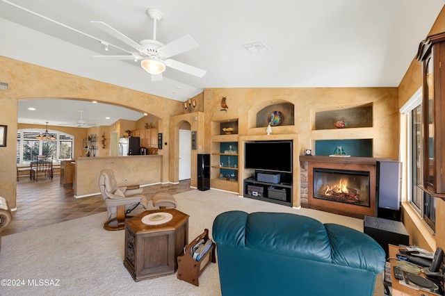 tiled living room featuring ceiling fan, vaulted ceiling, and built in features