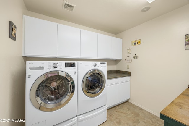 clothes washing area with independent washer and dryer and cabinets