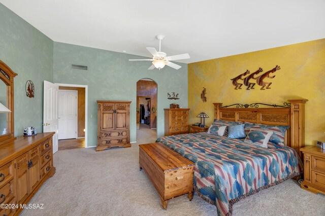 carpeted bedroom with ceiling fan and a towering ceiling