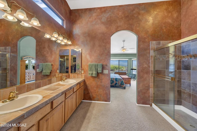 bathroom featuring ceiling fan, walk in shower, a towering ceiling, and vanity