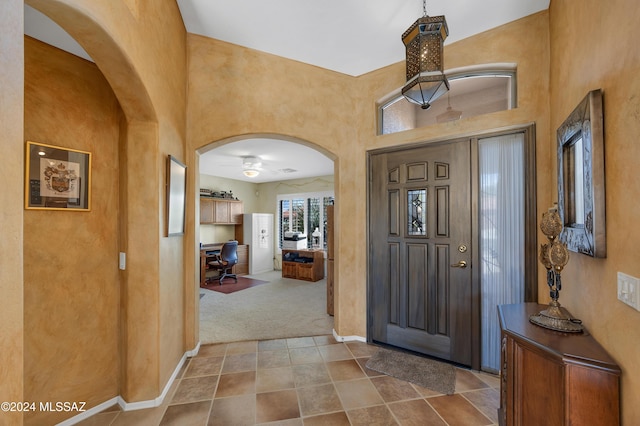 carpeted foyer with a towering ceiling