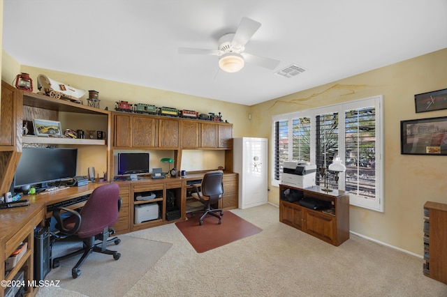 carpeted office space featuring ceiling fan