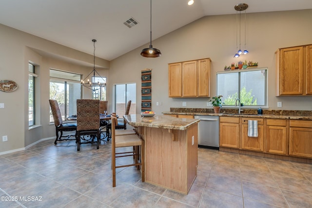 kitchen with pendant lighting, a center island, stainless steel dishwasher, and sink