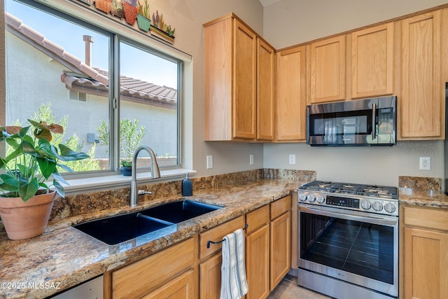 kitchen featuring light stone countertops, sink, and appliances with stainless steel finishes