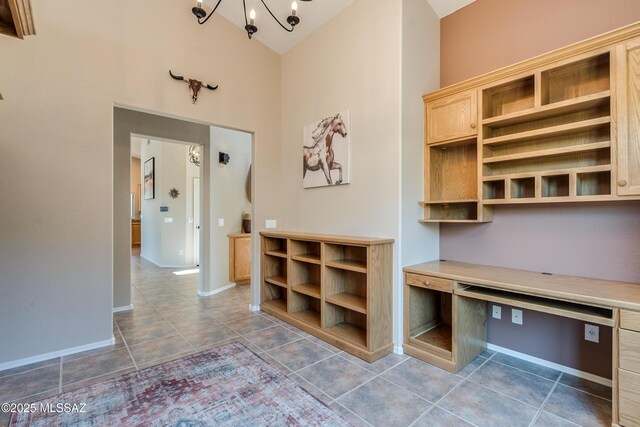 mudroom with built in desk, high vaulted ceiling, and an inviting chandelier