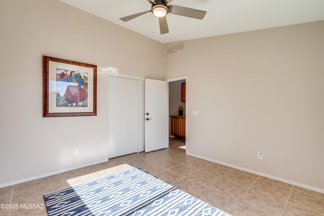 unfurnished bedroom with high vaulted ceiling, ceiling fan, and light tile patterned flooring