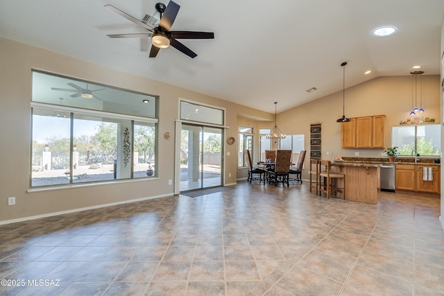 living room with light tile patterned floors, ceiling fan with notable chandelier, vaulted ceiling, and sink