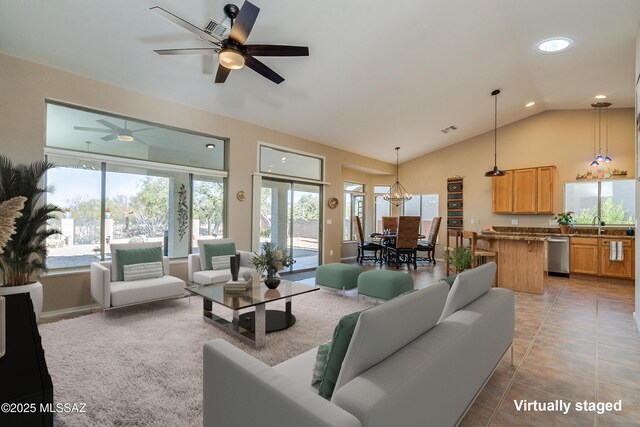 living room with vaulted ceiling, light tile patterned floors, and ceiling fan with notable chandelier