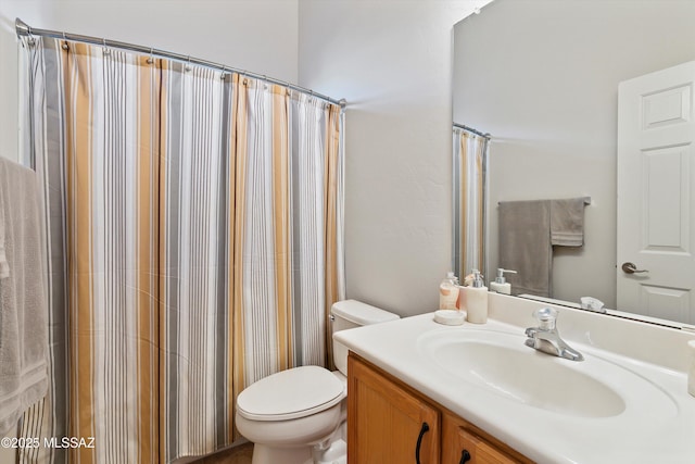 bathroom featuring curtained shower, vanity, and toilet