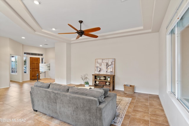 tiled living room with a tray ceiling and a healthy amount of sunlight