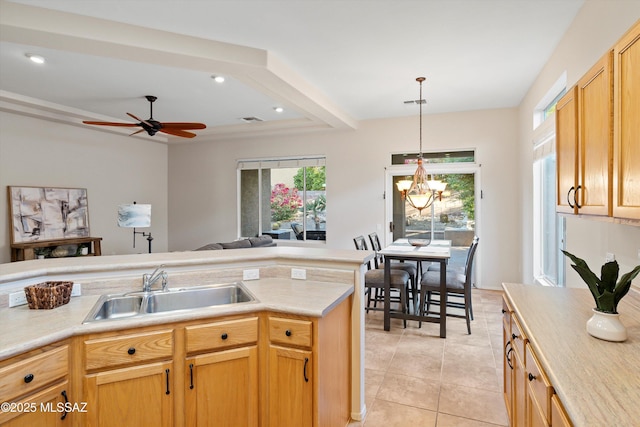 kitchen with light brown cabinets, sink, decorative light fixtures, light tile patterned flooring, and ceiling fan with notable chandelier