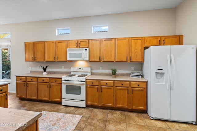 kitchen featuring white appliances and a high ceiling