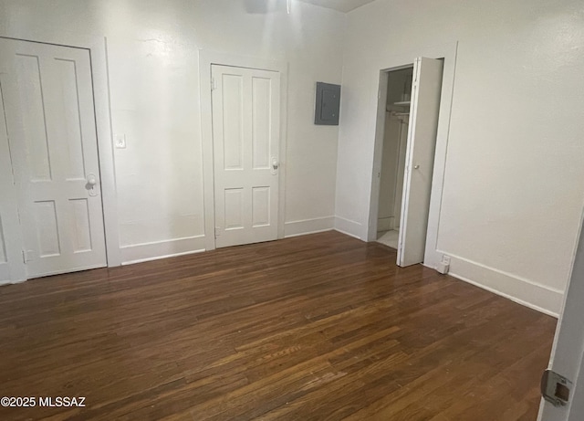 unfurnished bedroom with electric panel and dark wood-type flooring