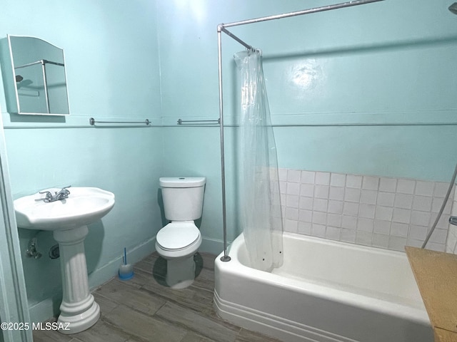 bathroom with wood-type flooring, shower / bath combo, and toilet