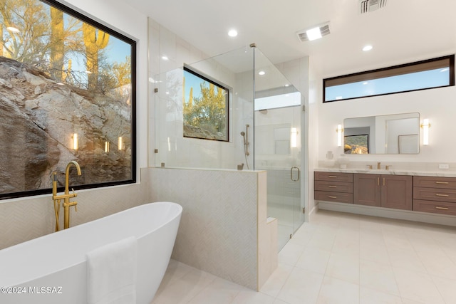 bathroom with vanity, shower with separate bathtub, and tile walls