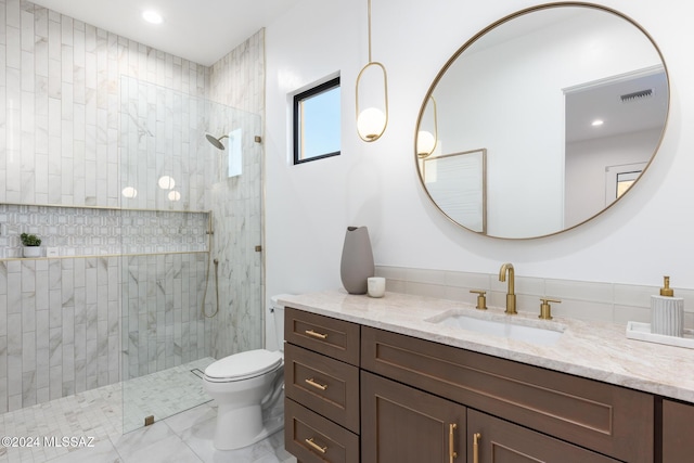 bathroom featuring vanity, toilet, and tiled shower