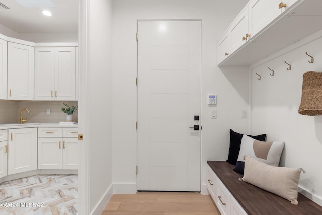 mudroom with light hardwood / wood-style floors and sink