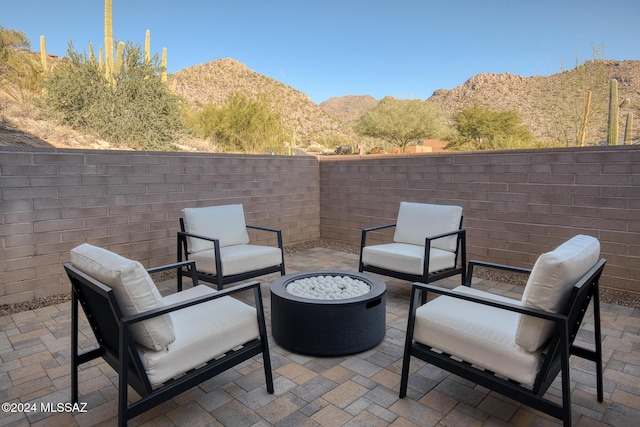 view of patio / terrace with a fire pit and a mountain view