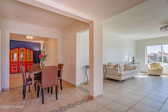 tiled dining space with a textured ceiling