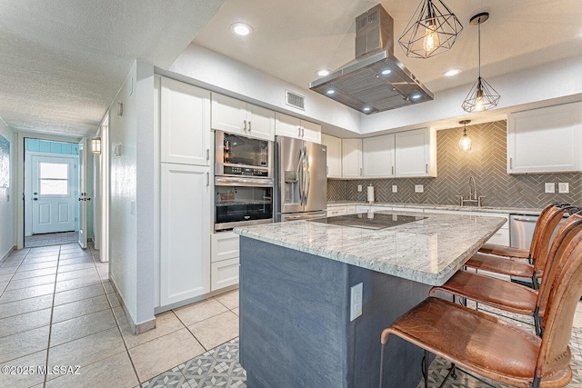 kitchen with a kitchen island, island range hood, decorative light fixtures, white cabinets, and stainless steel appliances