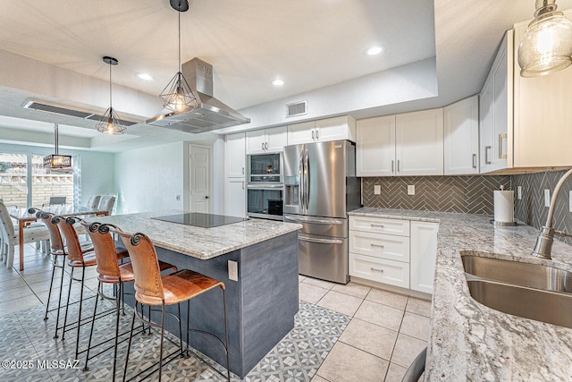 kitchen featuring light stone countertops, black appliances, white cabinets, and island exhaust hood