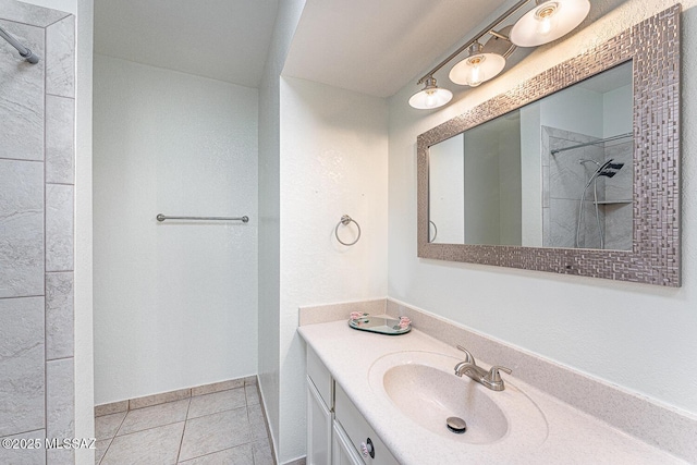 bathroom with tile patterned floors, vanity, and a tile shower