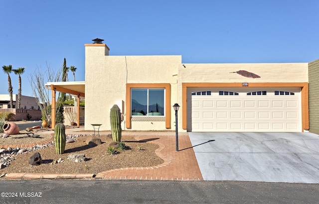 pueblo revival-style home featuring a garage