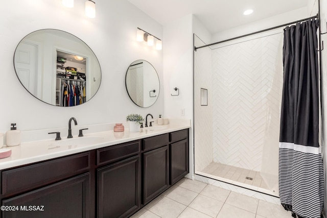 bathroom featuring tile patterned flooring, vanity, and walk in shower