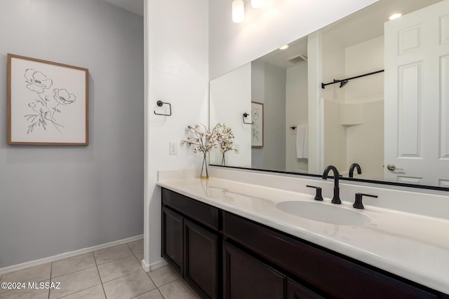 bathroom featuring tile patterned flooring, vanity, and walk in shower