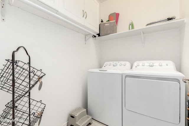 laundry area with cabinets and washing machine and clothes dryer